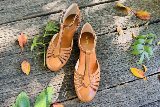 The RIVIERA Flat Noisette combines warm brown leather with elegant floral brocade
