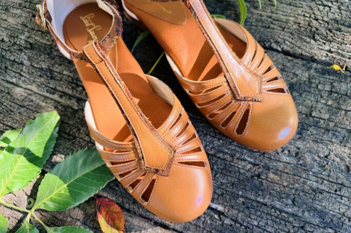 The RIVIERA Flat Noisette combines warm brown leather with elegant floral brocade Handmade in Europe, sustainable slow fashion. Shipping worldwide